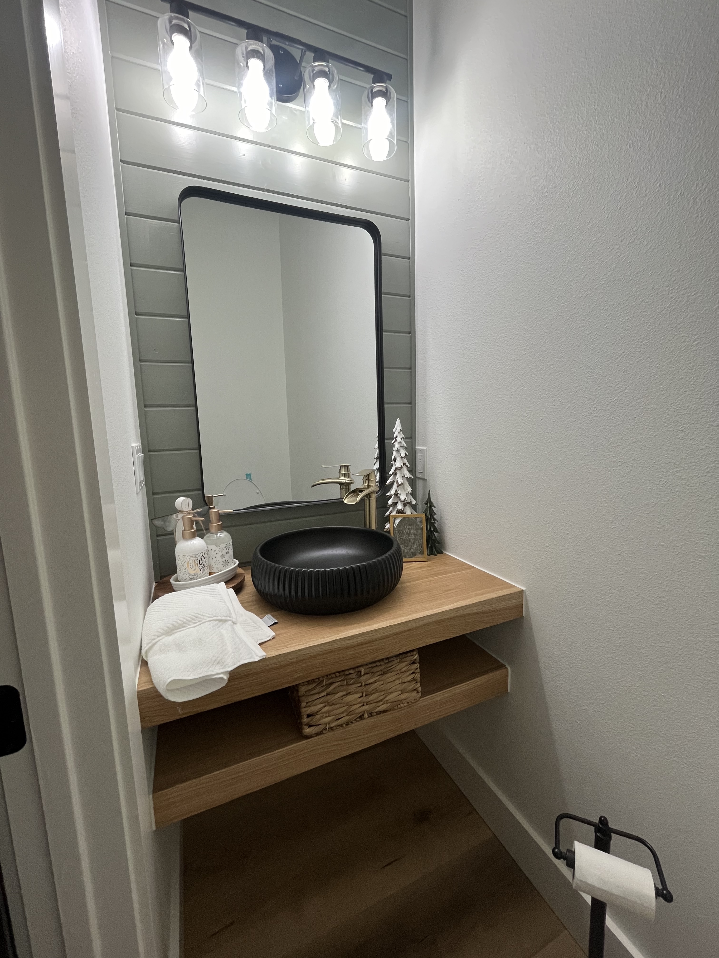 Modern powder room with floating white oak vanity and matte black vessel sink