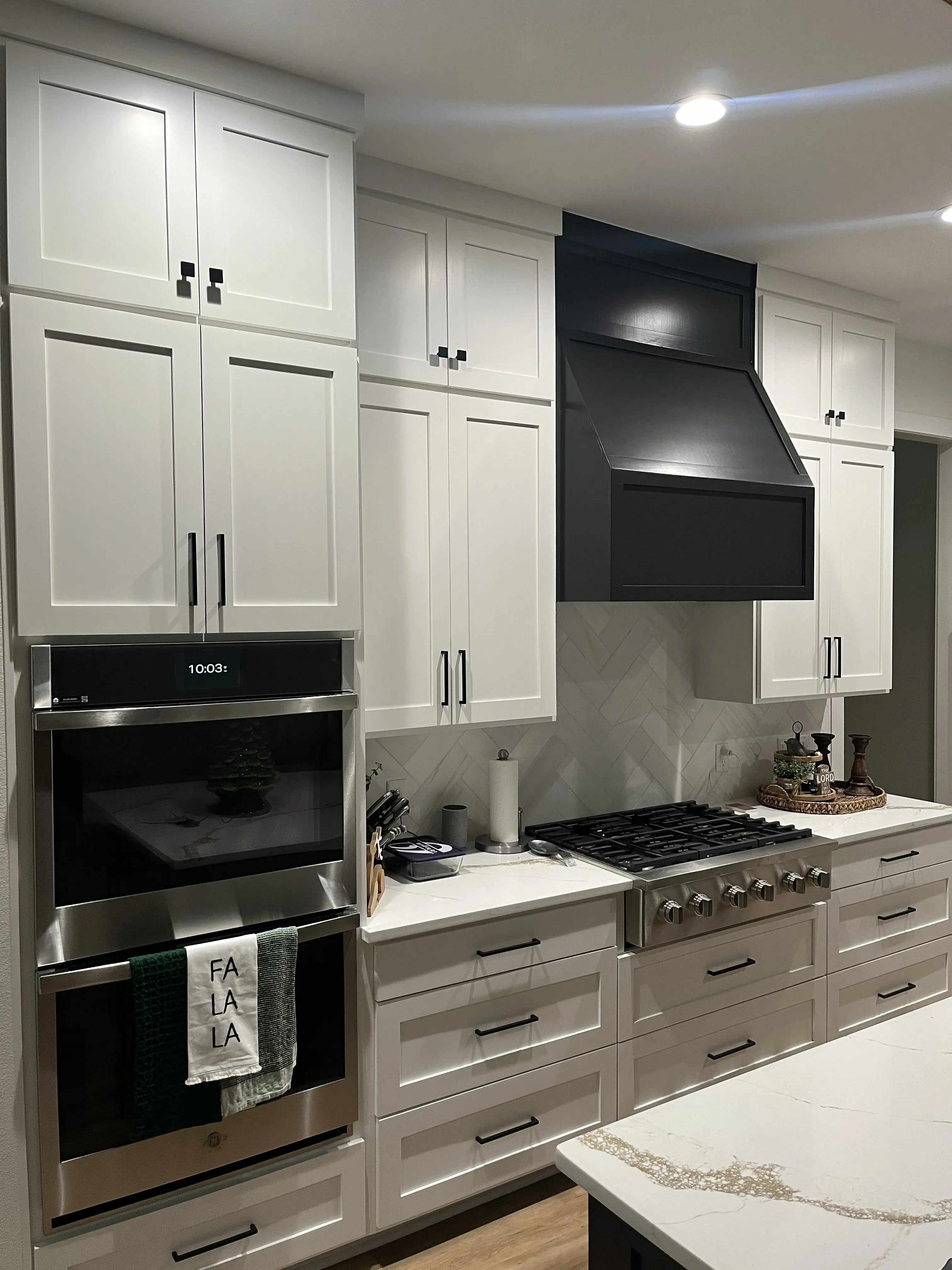 Tall white inset kitchen with custom black wood hood